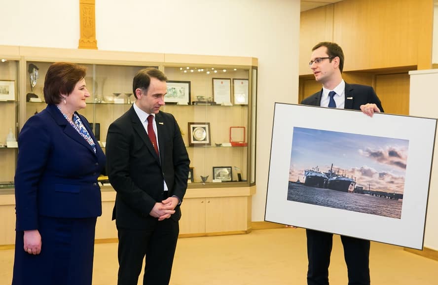 Seimo pirmininkė ir nebaigto terminalo statytojai džiaugiasi „užbaigtu“ projektu ir nupaveiksluotu bei įrėmintu laivo „Independence“ (vokiškai „Unabhängigkeit“) vaizdu. Nuotr. Seimo kanceliarijos