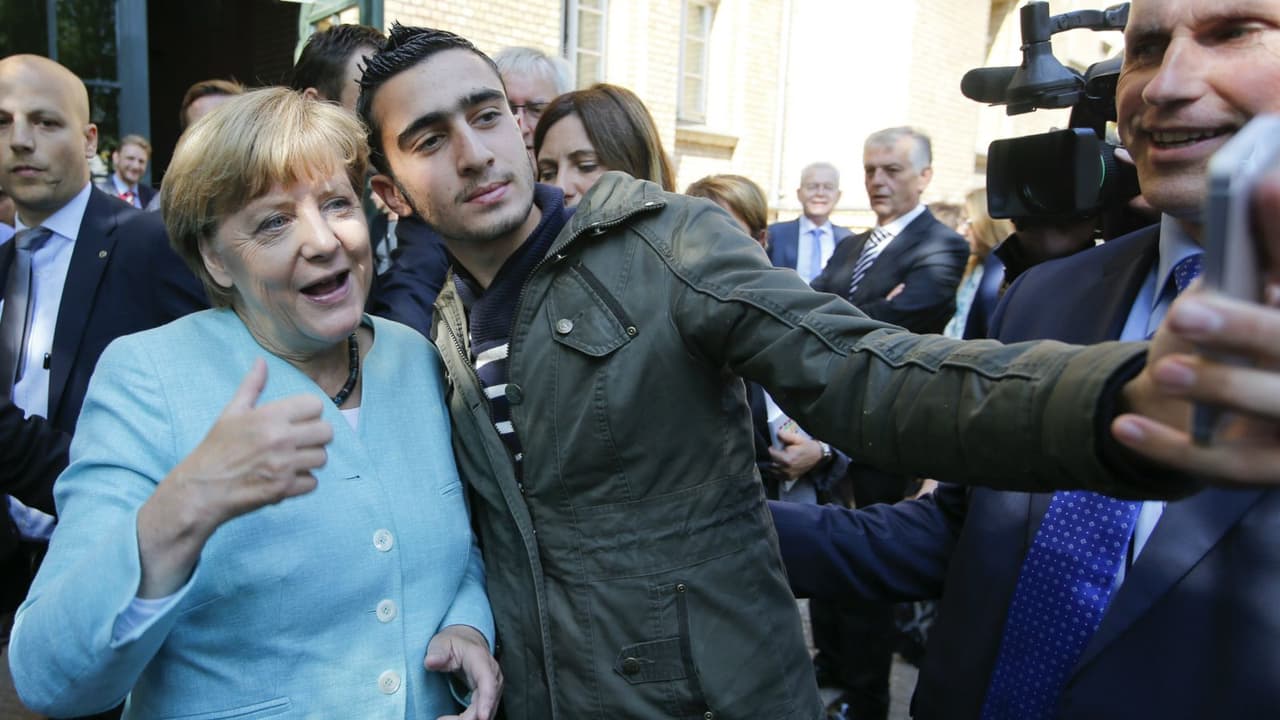 Angela Merkel ir migrantas. qzprod.files.wordpress.com nuotr.